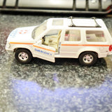 White diecast SUV emergency rescue vehicle with orange stripe and roof rack
