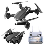 Foldable quadcopter drone with dark gray body and front camera, shown with RC controller screen