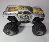 Gray and black diecast monster truck with large tread wheels and yellow details