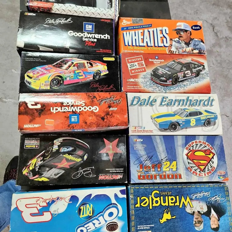 Diecast car lot in boxed NASCAR-style racing designs, stacked in two rows