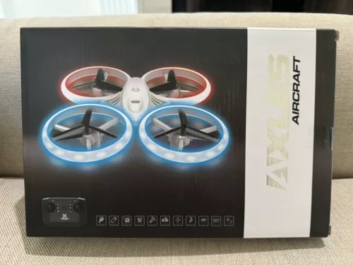 Mini quadcopter drone with red and blue LED prop rings, box packaging