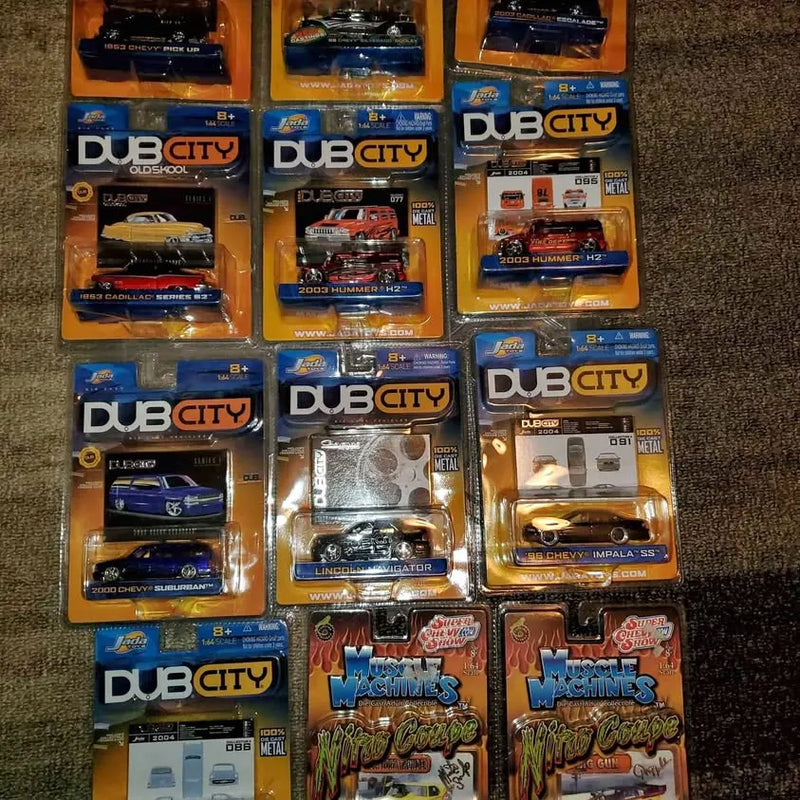 Dub City 1/64 diecast car collectibles in retail boxes, multiple models shown