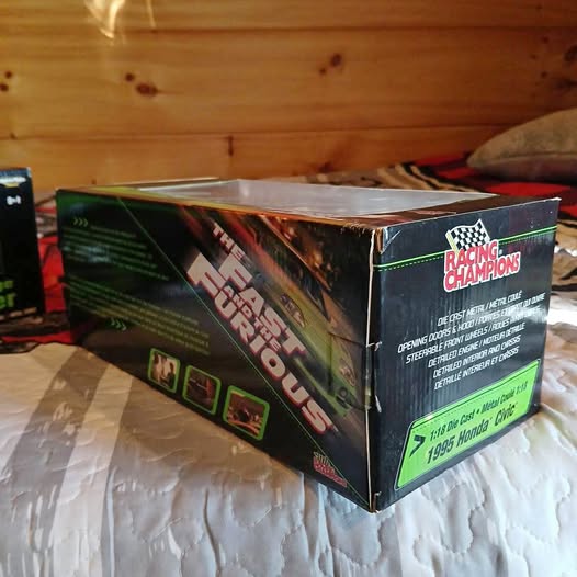 Diecast car display box with colorful graphics and checkered emblem