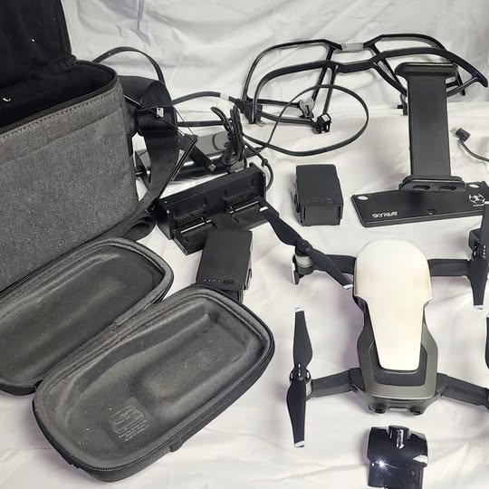 DJI drone kit with controller, batteries, and carry case, front and side view