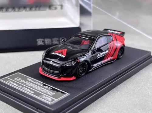 Black and red diecast sports car model, front three-quarter view on base