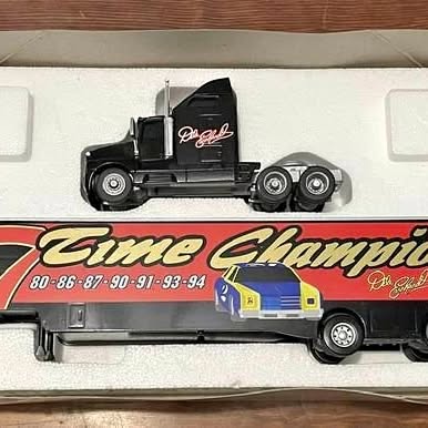Black diecast NASCAR-style truck model with wheels and cab details