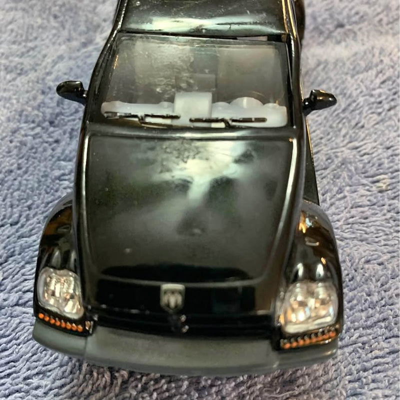 Diecast pickup truck model, dark green front with headlights and grille