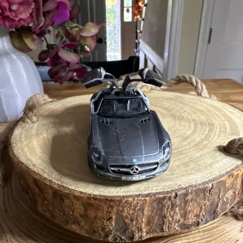 Diecast toy car model, front view, dark gray with Mercedes-style grille