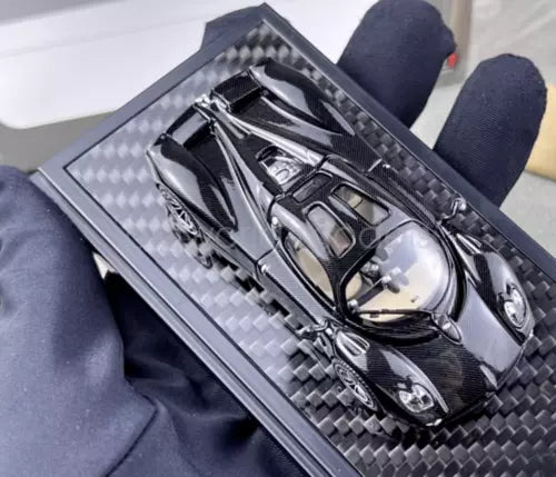 Black carbon-fiber diecast sports coupe model in display case