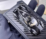 Black carbon-fiber diecast sports coupe model in display case