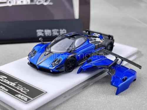 Blue diecast race car model with black engine bay and separate rear wing on base