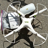 White quadcopter drone with four propellers and central body