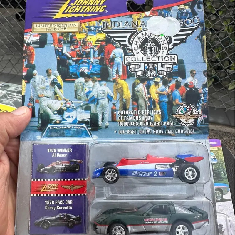 Diecast race car model in retail blister pack, blue and white #2 car shown