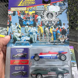 Diecast race car model in retail blister pack, blue and white #2 car shown