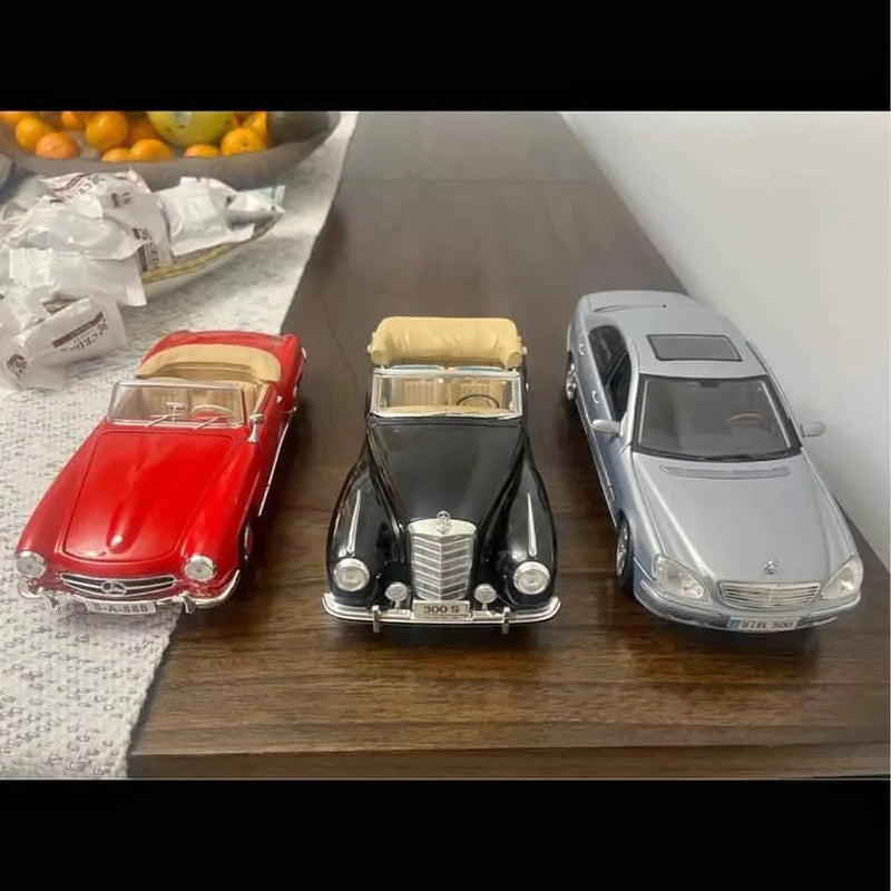 Set of three 1:18 diecast cars in red, black, and silver, front views on display