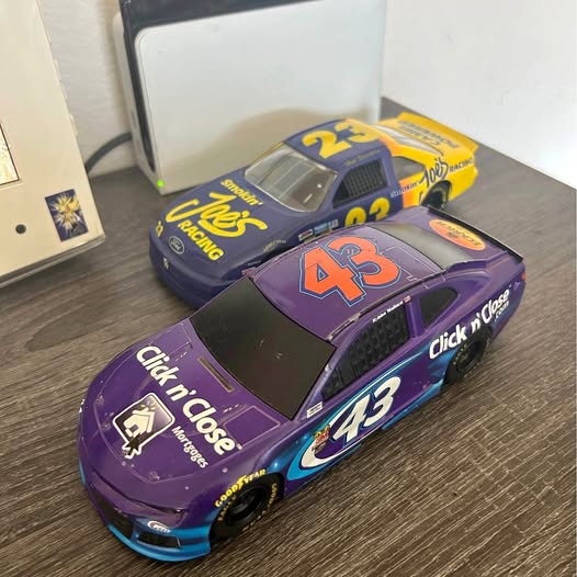 Purple and black diecast NASCAR race cars with printed logos, front three-quarter view