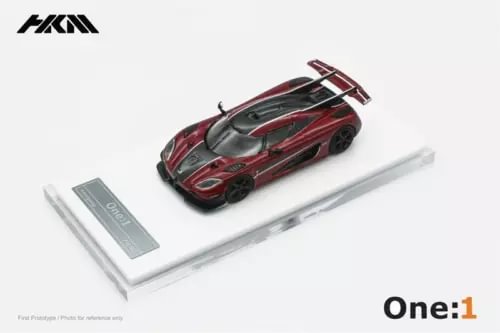 1:64 diecast sports car model in red and black with white stripes, on base