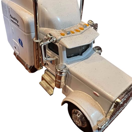 1:64 diecast semi truck with beige cab and chrome details, front wheel visible