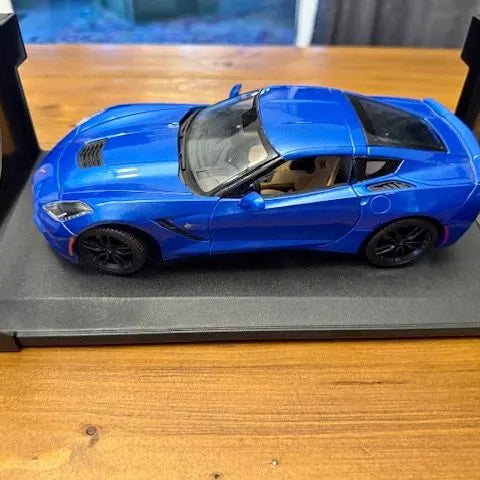 Blue 1/18 diecast model car with open hood, front three-quarter view