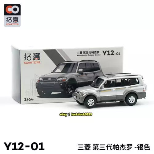 1/64 diecast SUV toy, silver with black windows, in front of gray model.