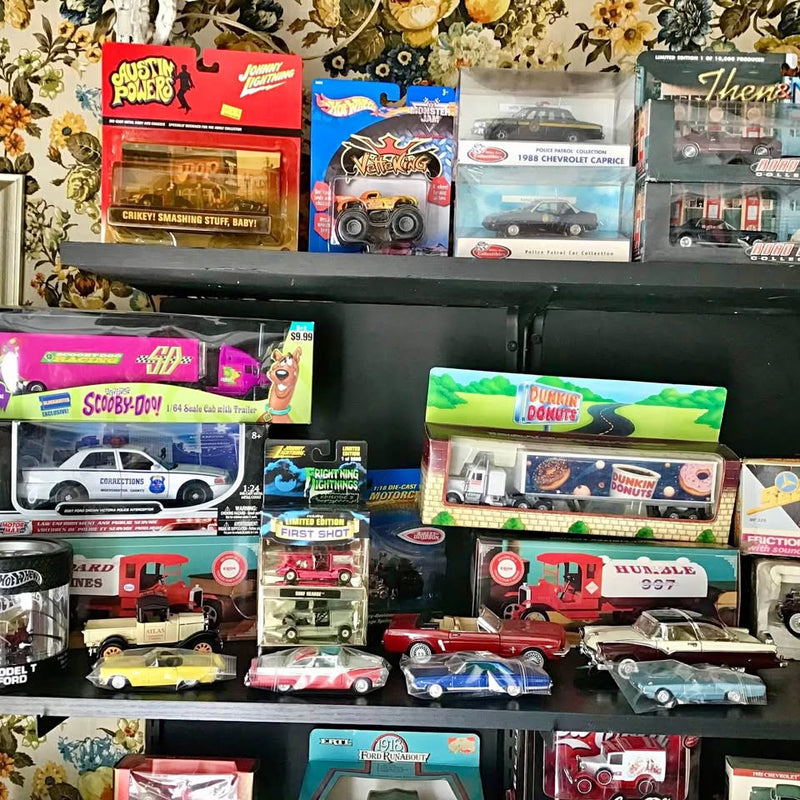 Assorted boxed diecast cars and HO model trains display, various colors