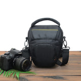 Black camera shoulder bag with top handle, front pocket, and adjustable strap