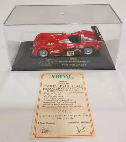 Red diecast race car model with black wheels in clear display case