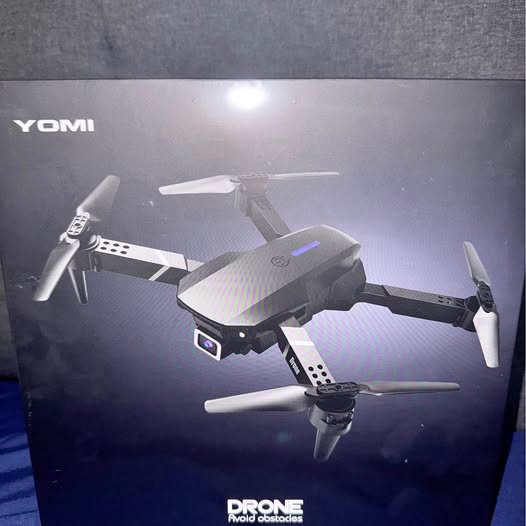 Gray quadcopter drone with four propellers, HD camera, on retail box