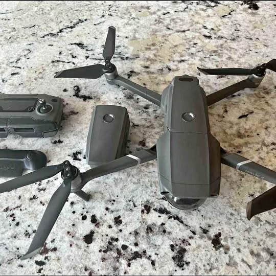 Dji Mavic 2 Pro drone with four propellers and remote controller on surface