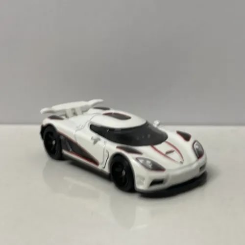 White 1/64 diecast sports car model with black wheels and rear spoiler
