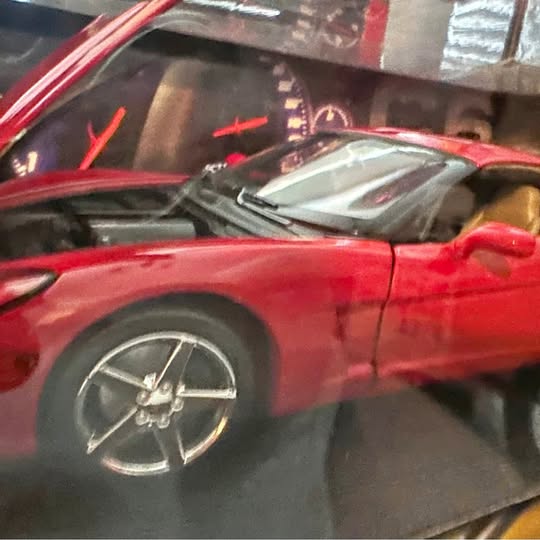 Red diecast Chevrolet Corvette C6 model, front side view with spoke wheels