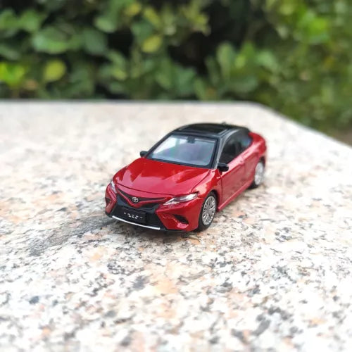 Red diecast model car with front grille and headlights, front 3/4 view