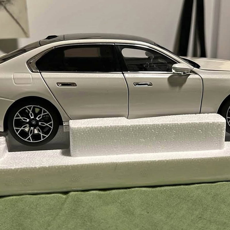 Metallic white diecast car model, front-side view with black alloy wheels
