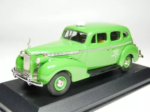 Green diecast touring sedan model car with chrome front grille, side view on display base