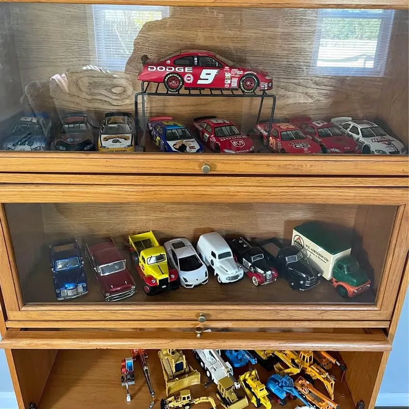 Diecast car collection in wooden display cabinet with multiple race cars
