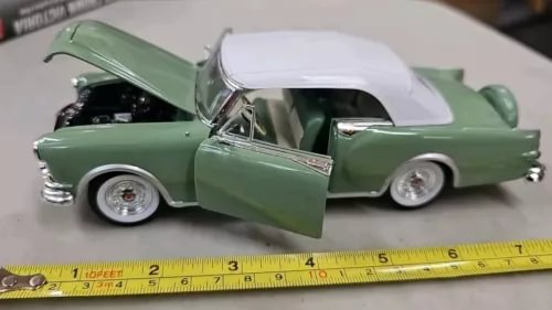 Green diecast 1953 Packard car model with white soft top and chrome details