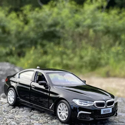 Black BMW M550i diecast car model toy, front three-quarter view with silver wheels