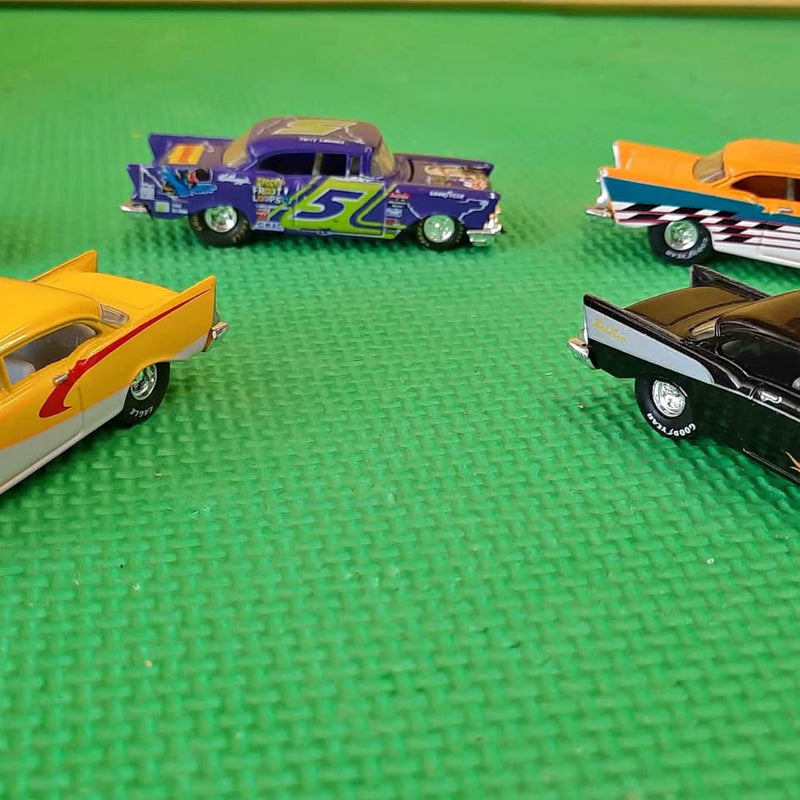 Diecast model cars: purple #57, orange, and black with white wheels