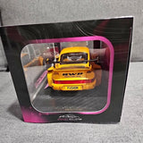 Yellow diecast race car in retail box with clear window