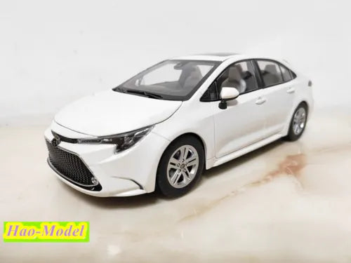 Diecast metal car model, white sedan with black grille and front-left view, detailed wheels