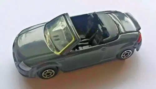 Dark gray diecast convertible car with open roof, black seats and detailed wheels