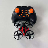 Mini quadcopter drone with orange-trim black controller, four rotors