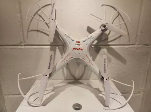 White quadcopter RC drone with four propeller arms