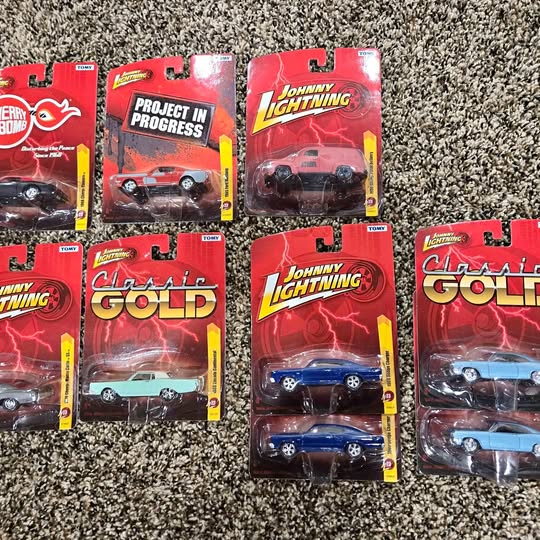 Johnny Lightning diecast car blister packs, assorted designs in red packaging