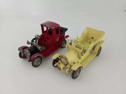 Vintage diecast car models with open chassis, red and pale yellow