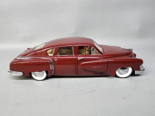 Red 1:24 scale diecast model car with side profile and whitewall tires