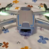 Blue and gray quadcopter drone with four propellers, front view