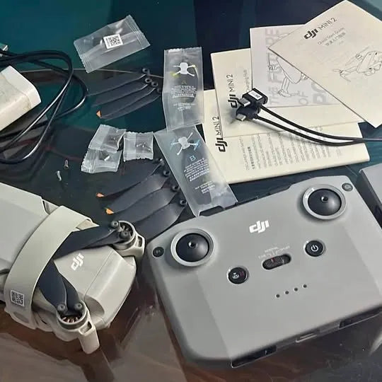 DJI Mini 2 drone with controller and Fly More combo accessories laid out