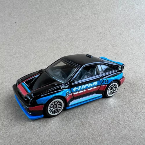 Black and blue diecast sports car with side graphics, 1:64 scale, loose toy