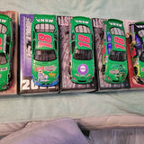 Diecast car in purple box with green, blue, and red racing car artwork